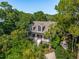 Aerial shot of a charming home nestled among mature trees with manicured landscaping and a welcoming front porch at 132 Turnberry Dr, Johns Island, SC 29455