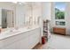 Bright bathroom featuring a double vanity, white cabinets, and natural light from an arched window at 132 Turnberry Dr, Johns Island, SC 29455