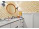 Bathroom with yellow patterned wallpaper, rattan mirror, and white vanity at 132 Turnberry Dr, Johns Island, SC 29455