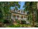 Charming home featuring a covered porch with white columns and stairs surrounded by lush greenery at 132 Turnberry Dr, Johns Island, SC 29455