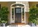 Charming front door with sidelights and decorative hardware, complemented by lush greenery at 132 Turnberry Dr, Johns Island, SC 29455