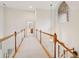 Bright hallway with white walls and wood railings, arched window, and neutral carpet flooring at 132 Turnberry Dr, Johns Island, SC 29455
