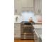 Close-up of a kitchen featuring a modern range with a white subway tile backsplash and white cabinetry at 132 Turnberry Dr, Johns Island, SC 29455