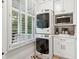 Bright laundry room with stacked washer and dryer and white cabinets at 132 Turnberry Dr, Johns Island, SC 29455