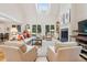 Sun-filled living room with vaulted ceilings, fireplace, and serene views of the backyard at 132 Turnberry Dr, Johns Island, SC 29455