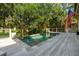 A relaxing backyard pool area is enhanced by a deck, the American flag and the verdant tree canopy overhead at 132 Turnberry Dr, Johns Island, SC 29455