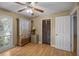 A room with a ceiling fan, wooden floors, a closet, a window, and a wooden cabinet with drawers at 133 Bramwell Dr, Summerville, SC 29485