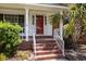 Cozy front porch with white columns and railings, offering a seating area with a view of the landscaped yard at 133 Bramwell Dr, Summerville, SC 29485
