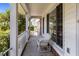 Relaxing front porch with white columns, offering a seating area with a view of the yard and street at 133 Bramwell Dr, Summerville, SC 29485