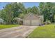 Charming home with a spacious driveway leading to a two-car garage, surrounded by lush greenery at 138 Wainwright Manor, Summerville, SC 29485
