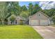 Landscaped exterior view of a brick and siding home with a large front yard and two car garage at 138 Wainwright Manor, Summerville, SC 29485