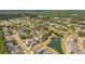 Aerial view of a residential community with tree-lined streets, a pond with a fountain, and green spaces at 1536 Keshi Pearl Dr, Mount Pleasant, SC 29466