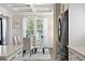 Elegant dining room with glass table, surrounded by large windows, and stainless steel refrigerator at 1536 Keshi Pearl Dr, Mount Pleasant, SC 29466
