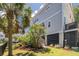 Well-maintained home exterior with a lush lawn, mature palm trees, and access to an upper level deck at 1536 Keshi Pearl Dr, Mount Pleasant, SC 29466