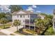 Beautiful two-story home with a screened-in porch, garage, and lush landscaping, surrounded by palm trees at 1536 Keshi Pearl Dr, Mount Pleasant, SC 29466