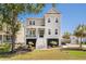 Charming gray two-story home boasts inviting front porch, manicured lawn, and lush landscaping on a sunny day at 1536 Keshi Pearl Dr, Mount Pleasant, SC 29466