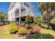 Home exterior featuring a beautifully landscaped yard, multi-level decks, and a charming garden at 1536 Keshi Pearl Dr, Mount Pleasant, SC 29466