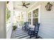 Relaxing front porch with rocking chairs, striped rug, ceiling fan, and open view at 1536 Keshi Pearl Dr, Mount Pleasant, SC 29466