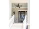 Inviting front porch features a welcoming entrance with black door, ceiling fan and 'Welcome' decor at 1536 Keshi Pearl Dr, Mount Pleasant, SC 29466