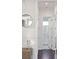 Hallway featuring wood floors leading to a bright bathroom with tiled shower at 1536 Keshi Pearl Dr, Mount Pleasant, SC 29466