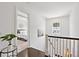 Upstairs hallway showcasing wood floors, natural light, and a glimpse of the bedroom at 1536 Keshi Pearl Dr, Mount Pleasant, SC 29466