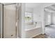 Bright bathroom showcasing a walk-in shower, soaking tub, and a view of the lake at 170 Highwoods Plantation Ave, Summerville, SC 29485