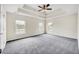 Spacious main bedroom with tray ceiling, carpet flooring, and abundant natural light from three windows at 170 Highwoods Plantation Ave, Summerville, SC 29485