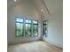 Bright bedroom with high vaulted ceilings and large black-framed windows offering serene outdoor views at 1727 Atlantic Ave, Sullivans Island, SC 29482