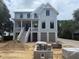 Two-story home featuring a classic design, inviting front porch, and construction materials at 1727 Atlantic Ave, Sullivans Island, SC 29482