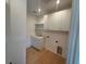 Laundry room featuring wooden floors, shaker cabinets, and light countertops at 1727 Atlantic Ave, Sullivans Island, SC 29482