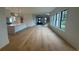 Open-concept living area showcasing hardwood floors, leading to a modern kitchen and entry stairs at 1727 Atlantic Ave, Sullivans Island, SC 29482