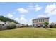 Expansive backyard with lush green grass, privacy fence, trampoline, patio, and grill area at 200 Topsaw Ln, Moncks Corner, SC 29461