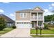 Charming two-story home with manicured lawn, a front porch, a balcony and a two-car garage at 200 Topsaw Ln, Moncks Corner, SC 29461