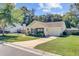 Yellow single-story home with manicured lawn, attached garage, and driveway in a residential neighborhood showcases classic design at 2076 Presidio Dr, Mount Pleasant, SC 29466