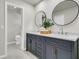 Bathroom features a dual vanity with modern fixtures, round mirrors, and tile flooring at 220 Runnymede Ln, Summerville, SC 29485
