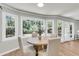 Charming dining area with a round table, surrounded by windows and natural light, and hardwood floor at 220 Runnymede Ln, Summerville, SC 29485