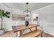 Dining area with a wooden table, bench seating, and a modern light fixture near kitchen entrance at 220 Runnymede Ln, Summerville, SC 29485