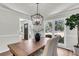 Light-filled dining room with a wood table, modern chandelier, and large windows at 220 Runnymede Ln, Summerville, SC 29485