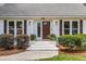 Welcoming front entrance with a stylish wooden door, decorative sconces, and well-kept landscaping at 220 Runnymede Ln, Summerville, SC 29485