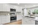 Stylish kitchen showcasing sleek stainless steel appliances, white cabinets, and a charming eat-in dining space at 220 Runnymede Ln, Summerville, SC 29485