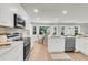 Modern kitchen features white cabinets, stainless appliances, and a spacious layout with a dining area at 220 Runnymede Ln, Summerville, SC 29485