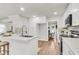 Bright kitchen featuring white cabinetry, a center island with seating, and a view into the dining room at 220 Runnymede Ln, Summerville, SC 29485