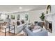 Spacious living room featuring comfortable seating, a decorative fireplace, and ample natural light from large windows at 220 Runnymede Ln, Summerville, SC 29485