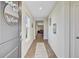 Welcoming hallway with wood-look floors, decorative artwork, and a 'welcome' sign on the front door at 325 Coral Sunset Way, Summerville, SC 29486