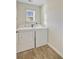 Bright laundry room with side-by-side washer and dryer units and hardwood floors at 325 Coral Sunset Way, Summerville, SC 29486