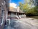 Brick home featuring a covered back porch with white railing and an expansive concrete patio at 3385 Wayland Dr, Ladson, SC 29456