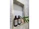 Close-up of a bathroom niche with shampoo, conditioner, and decorative plant at 3385 Wayland Dr, Ladson, SC 29456