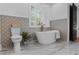 Charming bathroom featuring a modern toilet and tub with marble tile, plus natural light at 3385 Wayland Dr, Ladson, SC 29456