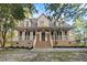 Inviting two-story brick home featuring a spacious front porch and mature trees at 3385 Wayland Dr, Ladson, SC 29456