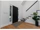 Bright foyer featuring a black door, hardwood floors, staircase, and a stylish area rug at 3385 Wayland Dr, Ladson, SC 29456